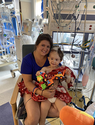 Mother holds child in recovery room.